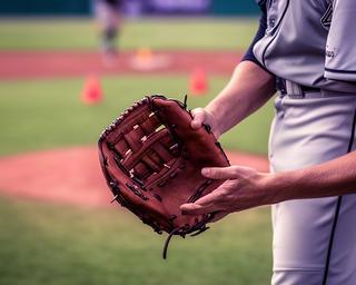 右投げ選手が左手にはめた内野手用グローブを持つ練習風景